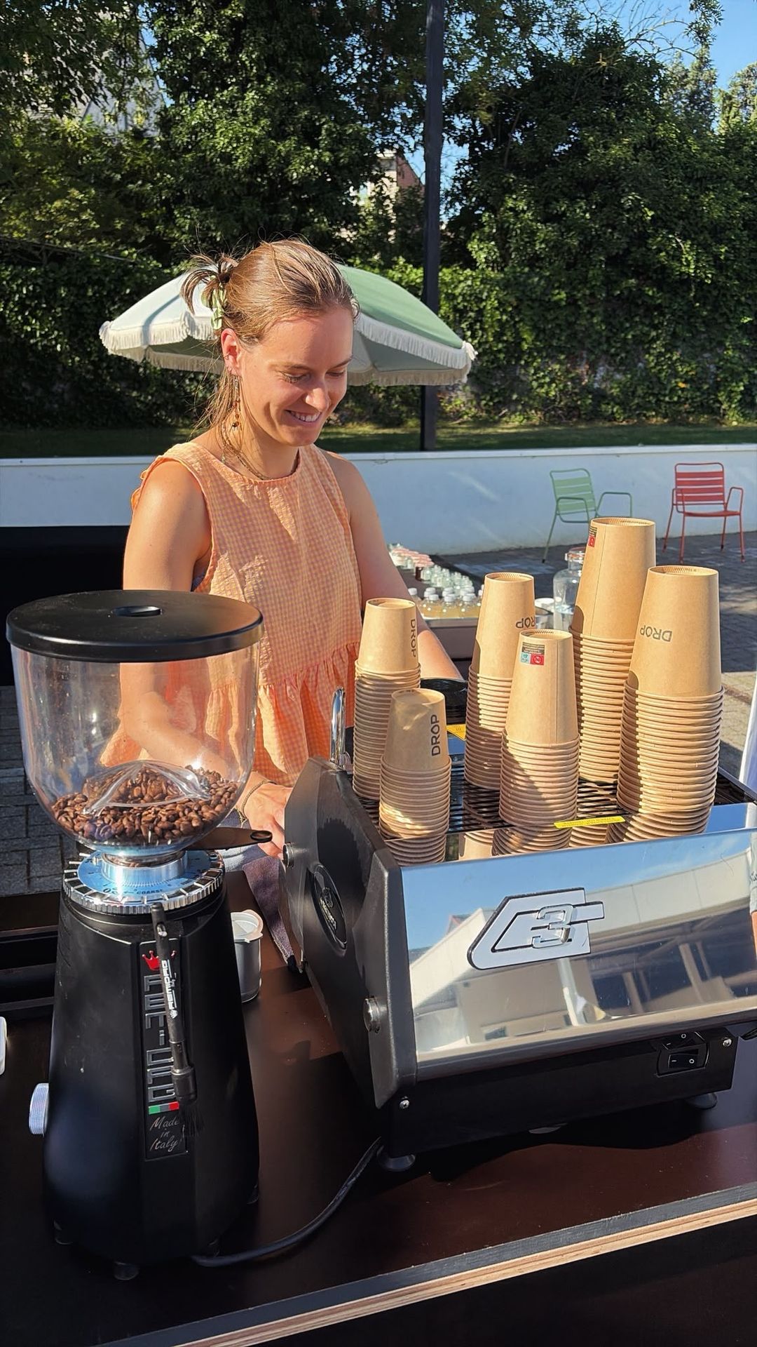 Barista aan de koffiemolen met Drop-bekers