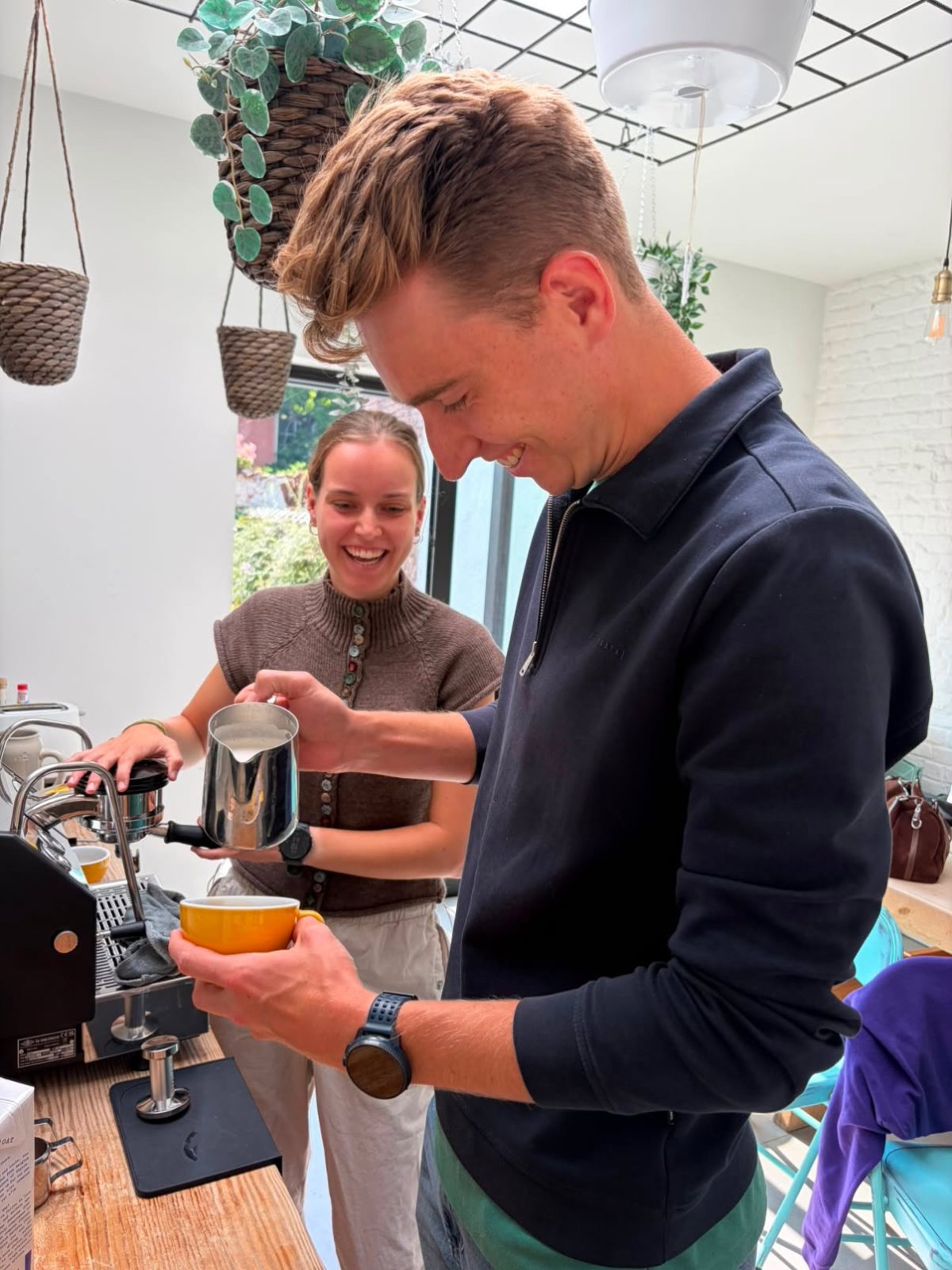 Deelnemers gieten melk tijdens een latte art workshop bij Drop